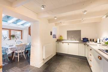 The kitchen and the glazed dining-area which connects to the deck and garden.