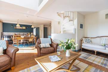 The stunning spiral staircase leads up from the living room onto the first floor.