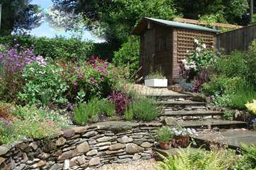 There is a gorgeous enclosed cottage garden at the back of the property. Stone steps lead up from the back door in the kitchen.