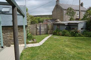 The garden runs alongside the cottage with the owners farmhouse at the rear of the picture.