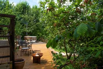 The large decked-area has a fire pit and charcoal barbecue.