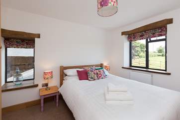 This is the first floor double bedroom. A lovely room with views out over the fields at the front and a glimpse of the oldest part of the farmstead at the side.