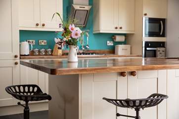 The island in the kitchen is perfect for those pre dinner drinks and nibbles.
