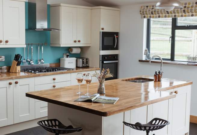 The island in the kitchen is perfect for those pre dinner drinks and nibbles.