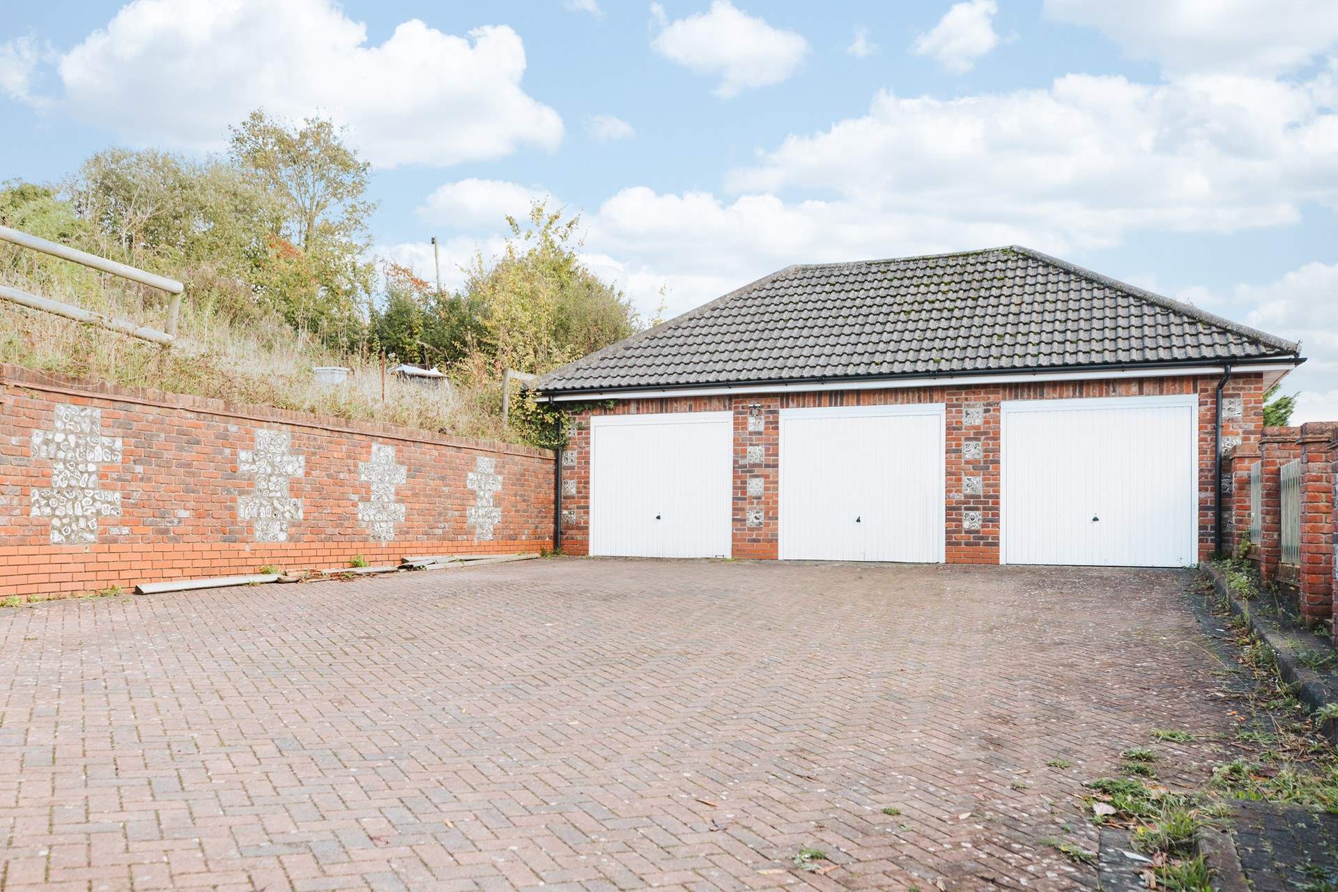 The parking space is in front of the middle garage.