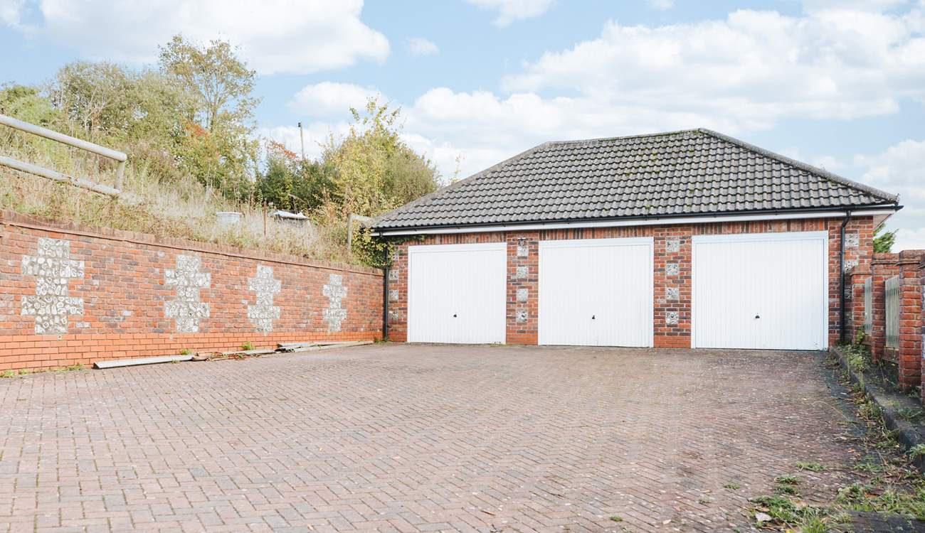 The parking space is in front of the middle garage.