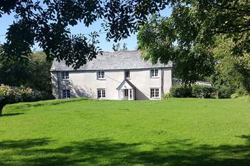 Eastcott Cottage has a lovely garden enclosed by a natural boundary and a slatted fence and gate.