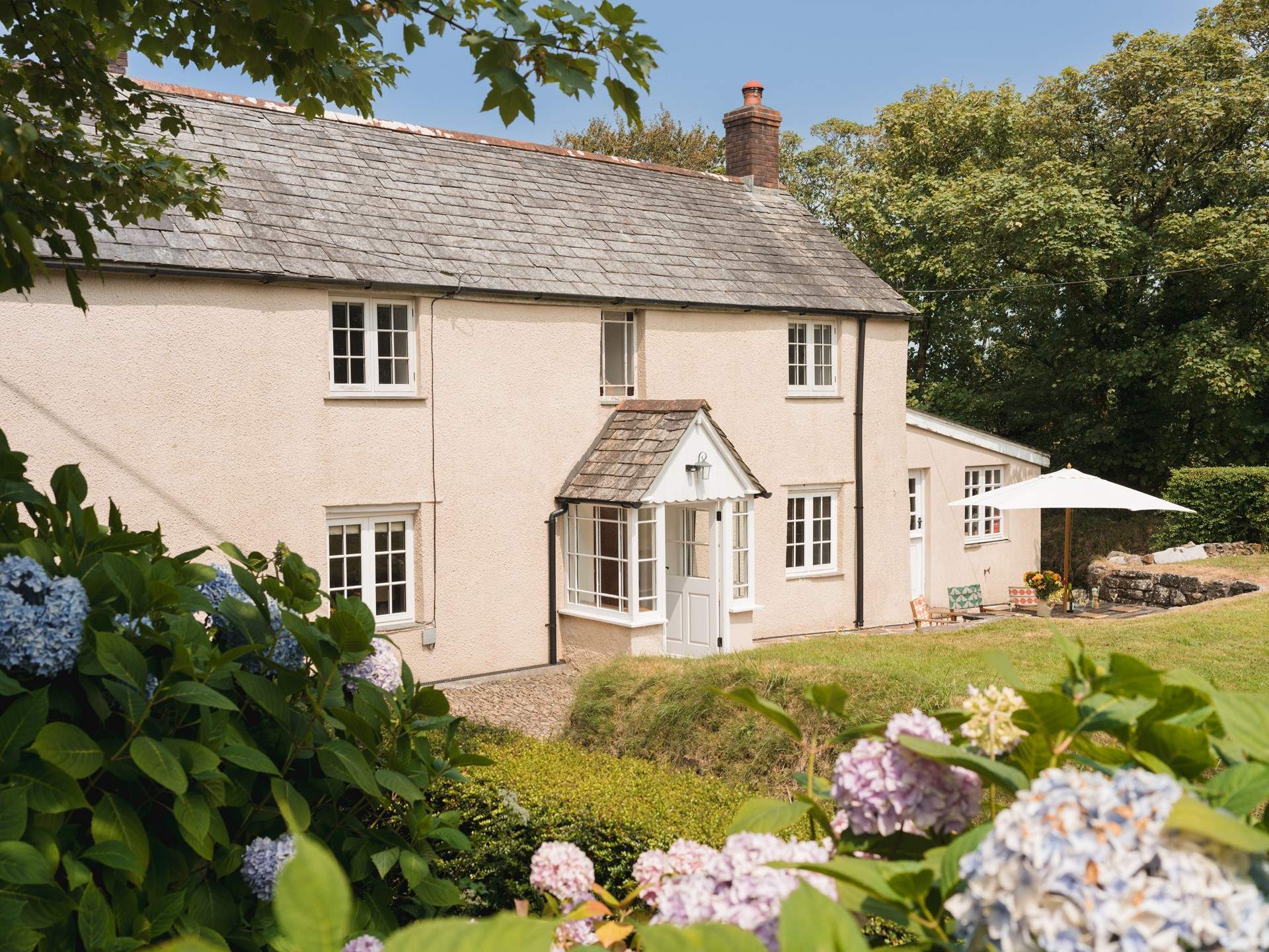 Eastcott Cottage has a lovely garden enclosed by a natural boundary and a slatted fence and gate. 