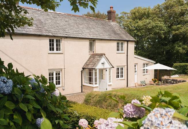Eastcott Cottage has a lovely garden enclosed by a natural boundary and a slatted fence and gate. 