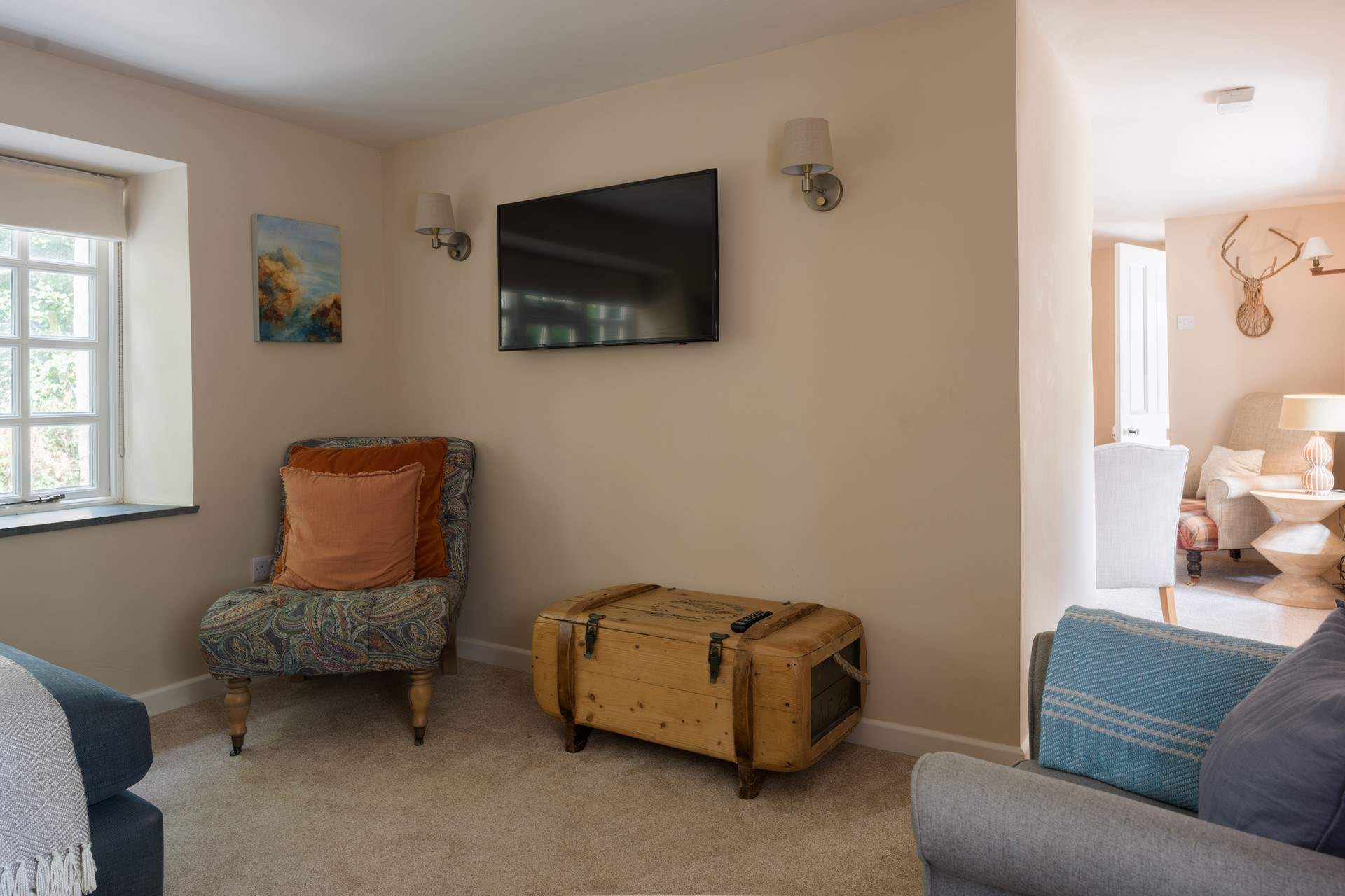 The sitting room has a film section and a reading nook with a log burner.
