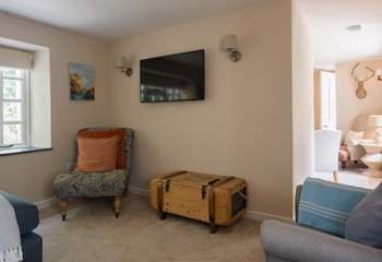 The sitting room has a film section and a reading nook with a log burner.