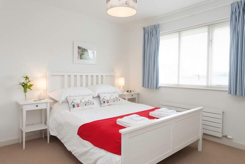 The master bedroom is decorated in crisp white tones, with a seaside theme.