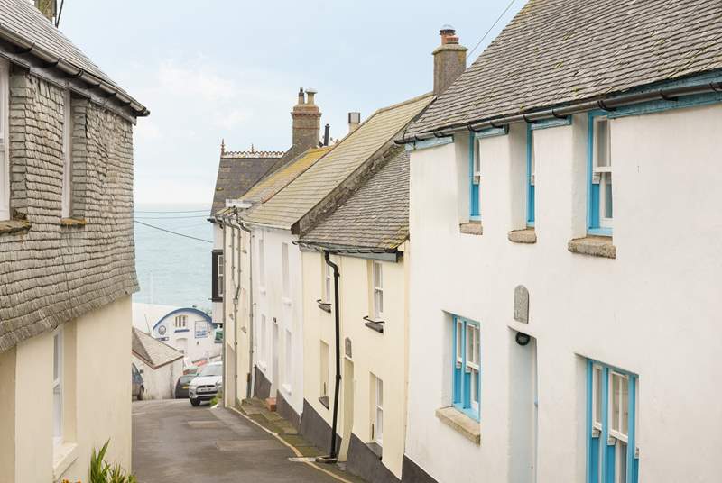 This pretty cottage with the blue door and windows sits on the hill close to the harbour, the pub and a short stroll to the beach.