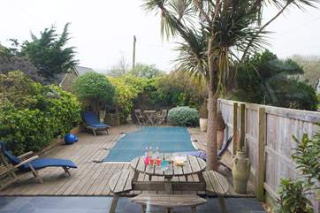 Open up the patio doors from the kitchen/ diner and walk out the decked pool area