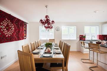 Cheeky red chandeliers hang over the dining-table.
