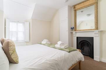 The double bedroom has a gorgeous ornamental fireplace.