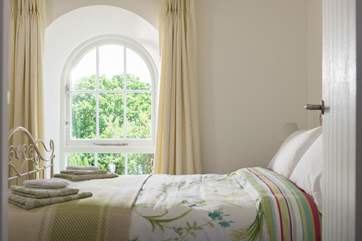 Another lovely arched chapel window allows light to pour into the bedroom.
