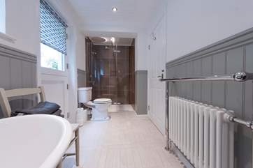 The shower is at the end of the bathroom.