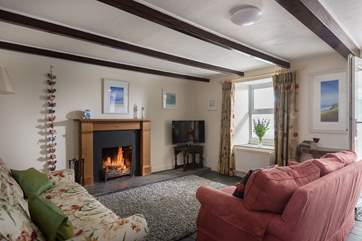 The cosy sitting-room with two sofas around the open fire.