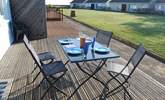 Enjoy breakfast on the decking with views across the communal lawn towards the sea. - Thumbnail Image