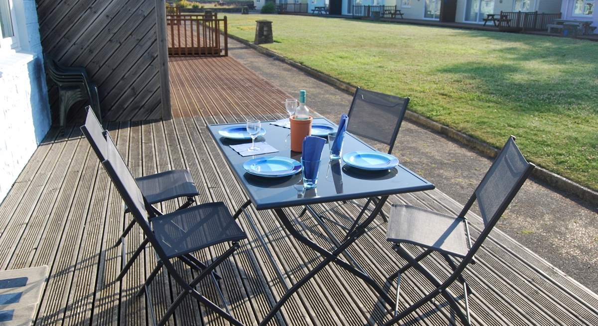 Enjoy breakfast on the decking with views across the communal lawn towards the sea.