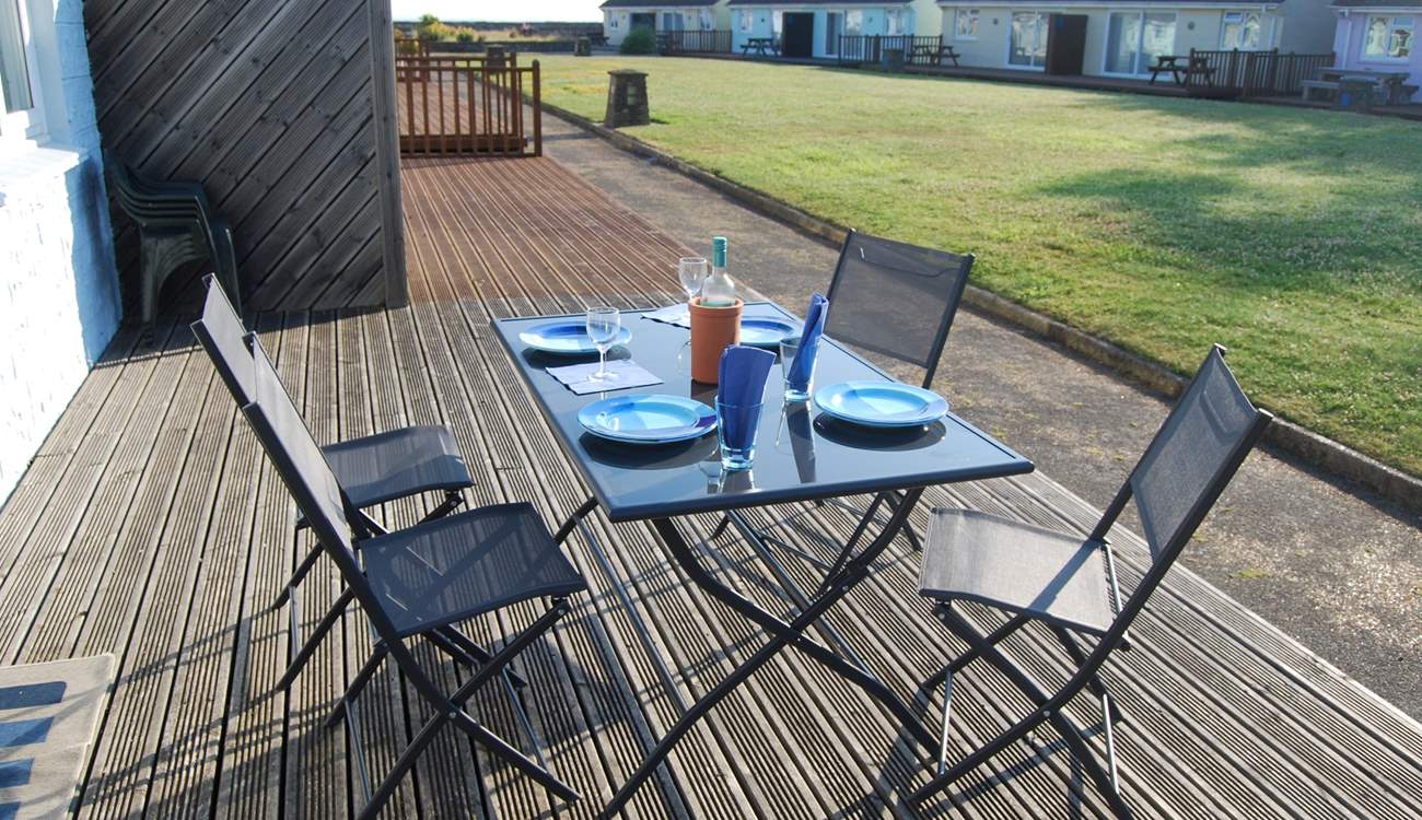 Enjoy breakfast on the decking with views across the communal lawn towards the sea.