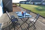 Enjoy breakfast on the decking with views across the communal lawn towards the sea.