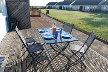 Enjoy breakfast on the decking with views across the communal lawn towards the sea.