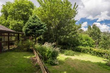 The conservatory overlooks the garden which is on two levels with steps from the top area down to the big lawn.
