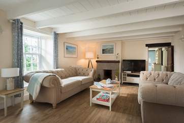 Two comfy sofas at one end of the living-room are placed in front of the ornamental fireplace.