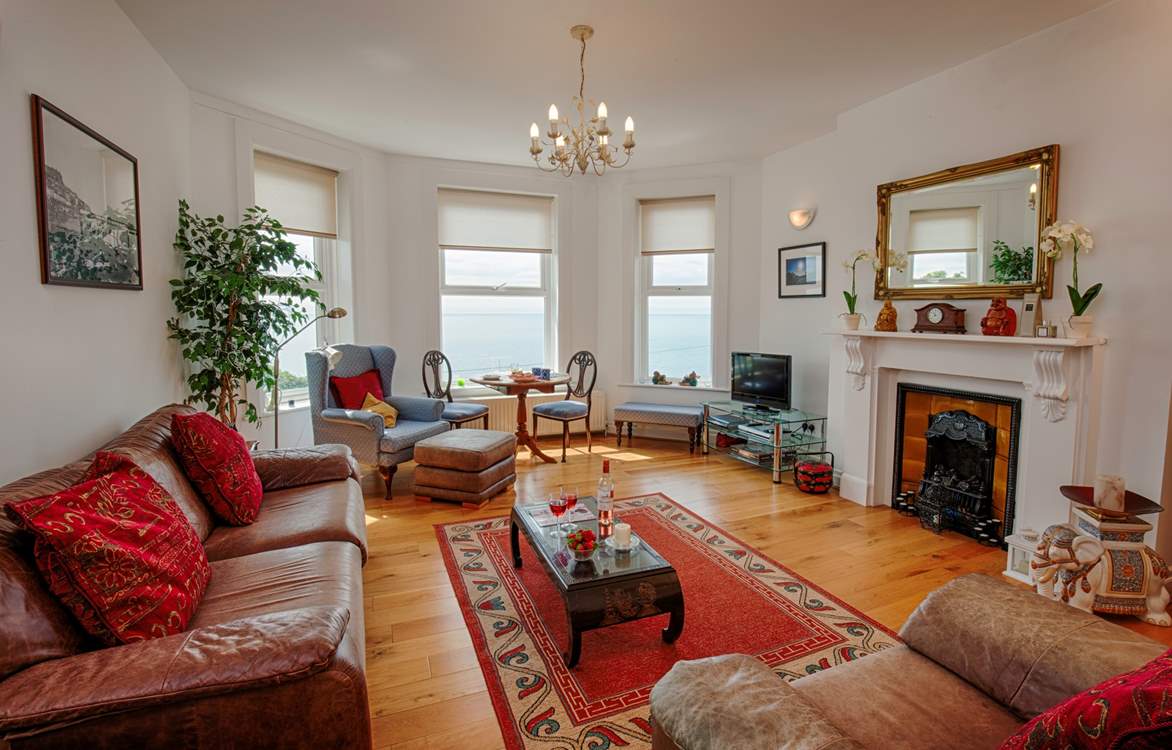 Lovely light and spacious living-room with plenty of comfortable seating to relax in.
