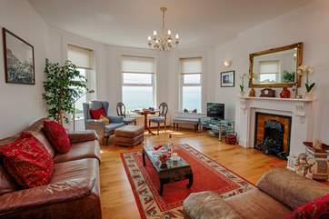 Lovely light and spacious living-room with plenty of comfortable seating to relax in.