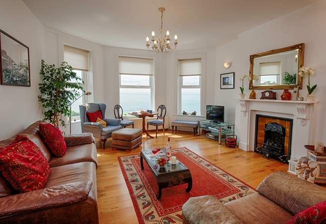 Lovely light and spacious living-room with plenty of comfortable seating to relax in.