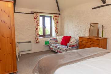 The bedroom retains lovely features and has a view down across the farm and fields.