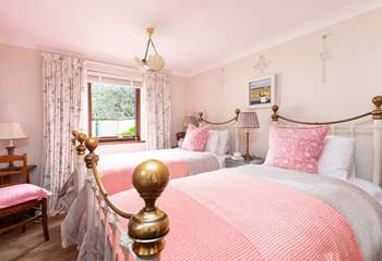 The sweet twin bedroom on the ground is decorated in warming hues. 