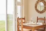 Sunlight pours through the French doors, beautifully illuminating the dining area. 