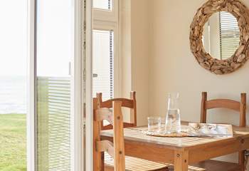 Sunlight pours through the French doors, beautifully illuminating the dining area. 