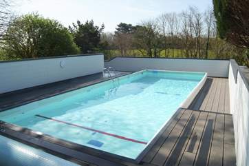The swimming pool is sheltered by fencing.