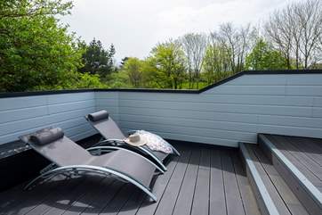 There are sun loungers around the pool for relaxing.