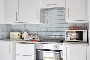 The modern kitchen has all the necessary appliances to make a meal at home.