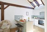 The modern kitchen has vaulted ceilings with skylights and wooden beams giving a lovely cottage feel throughout.