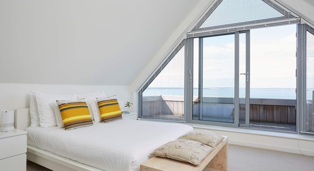 Bedroom 5 has doors opening out to the balcony, with seating to enjoy the fabulous view.