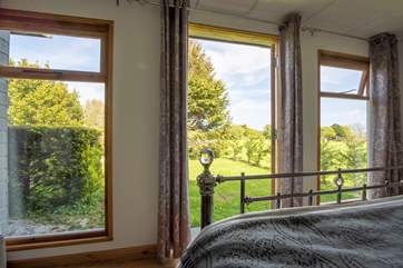 A bed with a view and double doors leading out to the garden area.