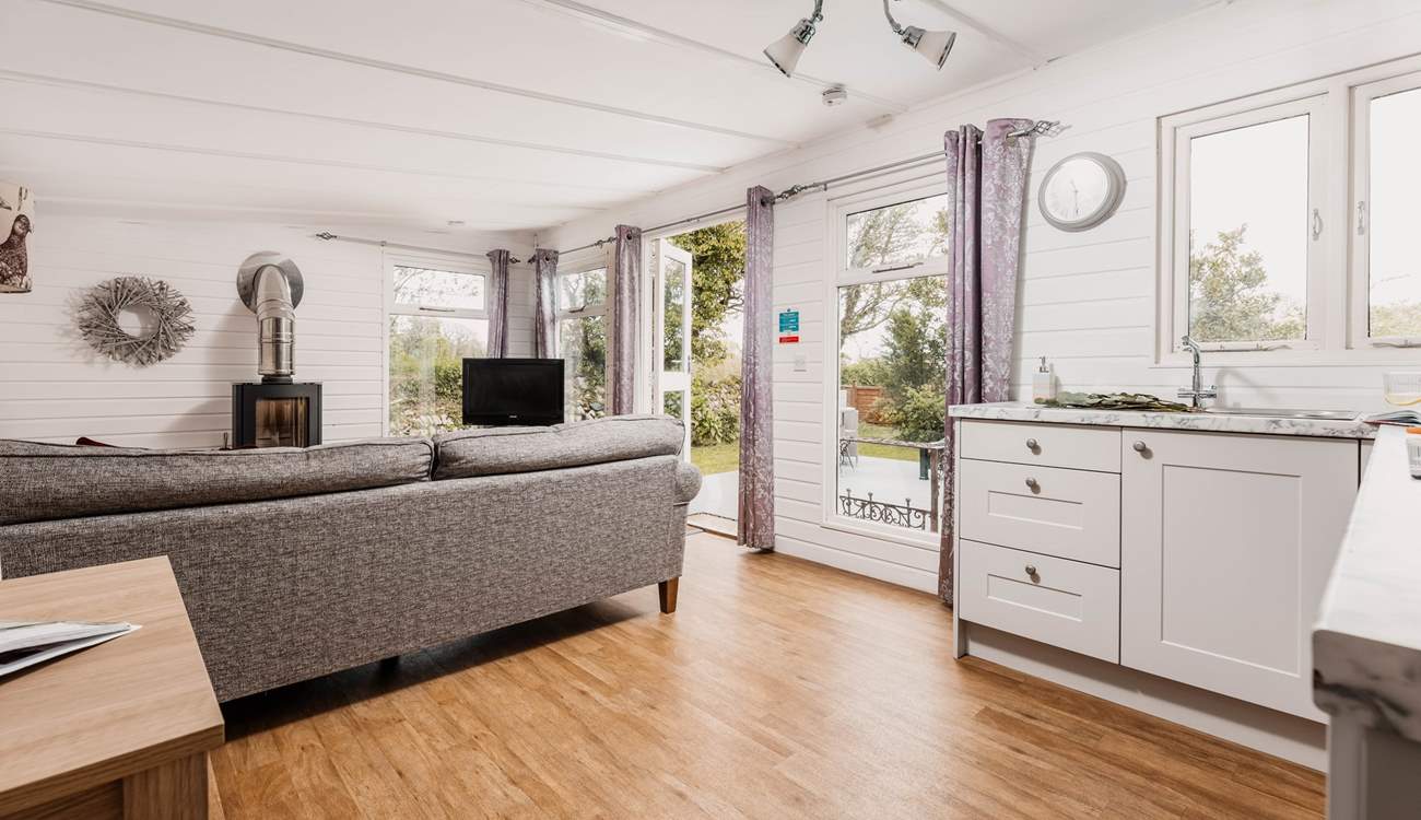 The light and airy living space is warmed by a wood-burner.
