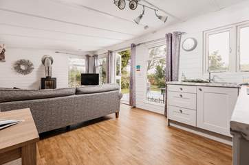 The light and airy living space is warmed by a wood-burner.