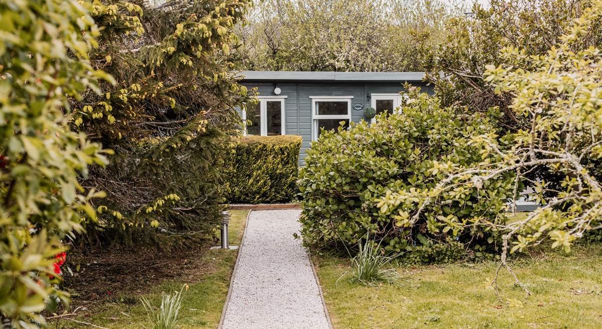 The tree lined path leads to Cuddle Cabin.