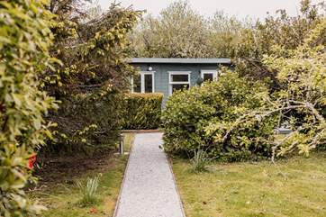 The tree lined path leads to Cuddle Cabin.