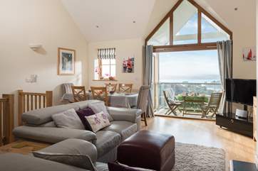 The open-plan living room has high vaulted ceilings and is flooded with light.