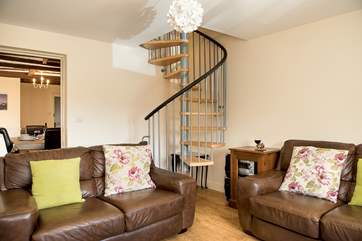 The second sitting-room/snug is an ideal space for those who might like some quiet time. The spiral stairs lead up to bedroom 4 on the mezzanine floor above.