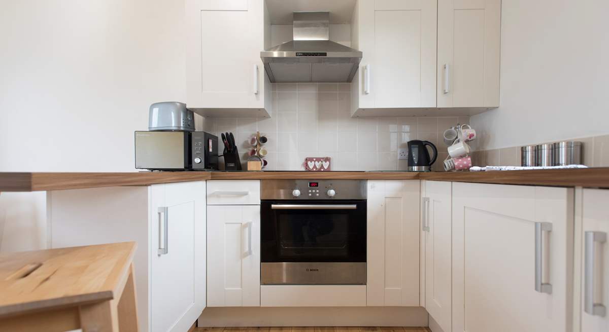 The kitchen is complete with an induction hob, and is compact, light and airy.